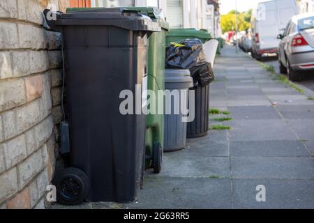 Mülltonnen und Recycling-Mülleimer vor den Häusern in einer englischen Straße Stockfoto