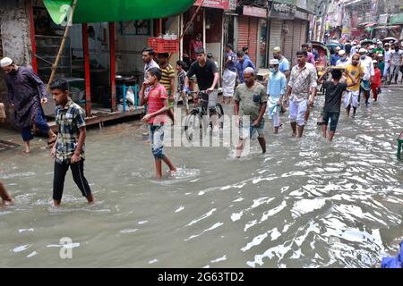 Dhaka, Bangladesch - 02. Juli 2021: In Dhaka, Bangladesch, versuchen Menschen, durch eine überflutete Straße zu gehen. Das Eindringen von Kanälen trägt zur Entwicklung bei Stockfoto