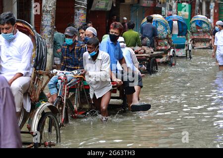 Dhaka, Bangladesch - 02. Juli 2021: Fahrzeuge versuchen, durch eine überflutete Straße in Dhaka, Bangladesch, zu fahren. Das Eindringen von Kanälen trägt zur Entwicklung bei Stockfoto