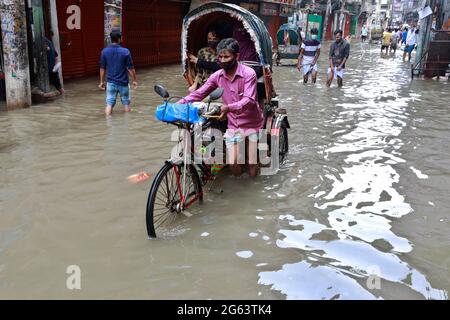 Dhaka, Bangladesch - 02. Juli 2021: Fahrzeuge versuchen, durch eine überflutete Straße in Dhaka, Bangladesch, zu fahren. Das Eindringen von Kanälen trägt zur Entwicklung bei Stockfoto