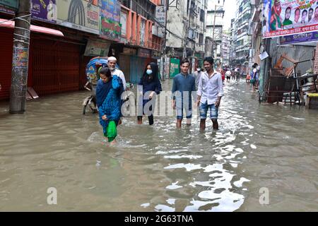 Dhaka, Bangladesch - 02. Juli 2021: In Dhaka, Bangladesch, versuchen Menschen, durch eine überflutete Straße zu gehen. Das Eindringen von Kanälen trägt zur Entwicklung bei Stockfoto