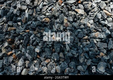 Grobe Steine, Schotter, Granitkies Nahaufnahme. Die raue Textur des Steins. Hintergrund des Baumaterials. Struktur Stockfoto