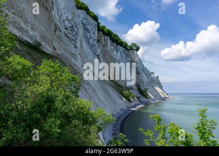 Zerklüftete weiße Kalksteinfelsen an der Ozeanküste mit üppig grünem Wald im Vordergrund Stockfoto