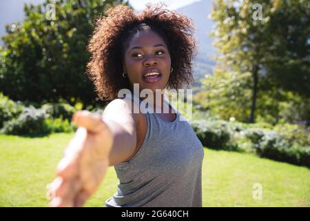 afroamerikanische Frau, die im sonnigen Garten Yoga praktiziert Stockfoto