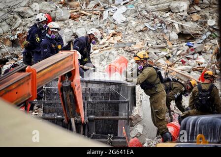 Surfside, Florida, USA. Juli 2021. FEMA Urban Search and Rescue Workers schließen sich den Ersthelfern an, die in der zusammengebrochenen Wohnanlage Champlain Towers South am 1. Juli 2021 in Surfside, Florida, Trümmer durchsieben. Quelle: Planetpix/Alamy Live News Stockfoto