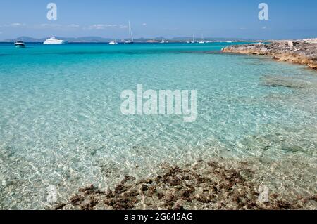 Panoramablick auf die Küste von Espalmador Insel Formentera, Spanien. Im Hintergrund luxuriöse verankerte Boote und der blaue Himmel Stockfoto