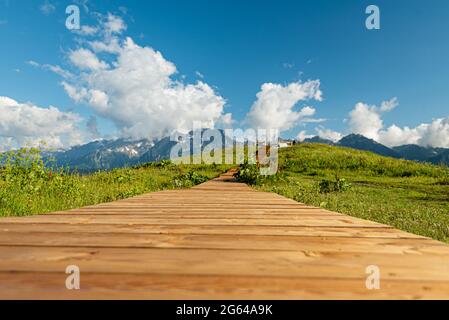 Holzboardwalk in den Bergen, die zu den Hügeln der Aussichtsplattform führt. Der Weg für das Brautpaar. Hintergrundtextur Kontrastsättigung Stockfoto