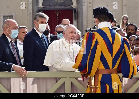 Während der Mittwochstaudienz von Papst Franziskus für die Gläubigen erlebte ich eine merkwürdige und angenehme Episode: Der Papst, nachdem er die Gläubigen im Hauptgang des Hofes von San Damaso begrüßt hatte, befand sich vor der Straße, die mit Barrieren verschlossen war, Während ihn die Gläubigen auf der anderen Seite riefen, um ihn näher zu bringen, da der Papst nicht näher kommen konnte, bat er die Schweizer Wache, die dort war, zuzusehen, dass sie vorbeikommen konnte. Aber unmittelbar danach erklärten sowohl die Wache als auch die Gendarmen dem Papst die Gründe für die Schließung, die von Sicherheit sind, um den Papst von der Approachi zu verhindern Stockfoto