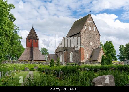 Gamla Uppsala, Schweden - 24. Juni 2021: Die historische alte und neue Kirche in Gamla Uppsala mit dem Friedhof im Vordergrund Stockfoto
