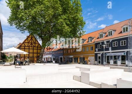 Koge, Dänemark - 12. Juni 2021- das historische alte Stadtzentrum von Koge mit einem Straßencafe im Freien unter einem grünen Baum an einem schönen Sommertag Stockfoto
