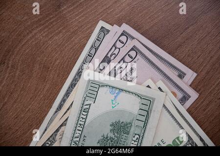 Nahaufnahme amerikanische Geldscheine von 50 Dollar und 100 Dollar Scheine, die mit eingeprägten Symbolen gekennzeichnet sind. Grüne und blaue Tinte seltsame Symbole auf Dollar-Schein gestempelt. Stockfoto