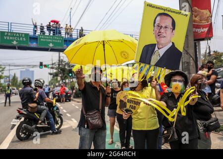 Unterstützer tragen Schilder, als sie sich vor seiner Beerdigung in Quezon City, Philippinen, neben der Autokolonne des ehemaligen philippinischen Präsidenten Benigno Aquino III versammeln. Stockfoto