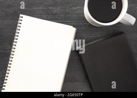 Eine einzelne schwarze Bibel auf einem schwarzen Holztisch Stockfoto