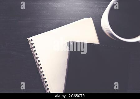 Eine einzelne schwarze Bibel auf einem schwarzen Holztisch Stockfoto