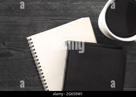 Eine einzelne schwarze Bibel auf einem schwarzen Holztisch Stockfoto