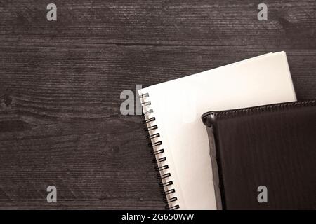 Eine einzelne schwarze Bibel auf einem schwarzen Holztisch Stockfoto