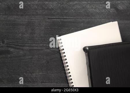 Eine einzelne schwarze Bibel auf einem schwarzen Holztisch Stockfoto