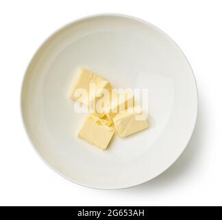 Butterstücke für die Zubereitung von Cremes in einer Schüssel isoliert auf weißem Hintergrund, Draufsicht Stockfoto