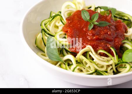 Zucchini-Pasta mit Tomatensauce und Basilikum Stockfoto