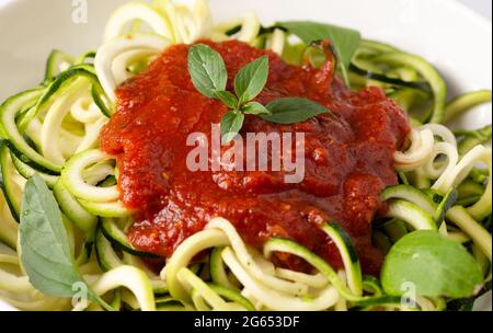 Zucchini-Pasta mit Tomatensauce und Basilikum Stockfoto