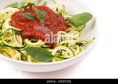 Zucchini-Pasta mit Tomatensauce und Basilikum Stockfoto