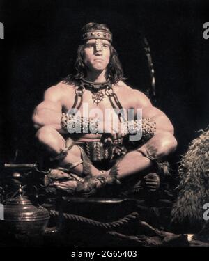 Arnold Schwarzenegger, sitzendes Porträt in voller Länge, Dreharbeiten zum Film, „Conan the Destroyer“, Universal Picters, 1984 Stockfoto