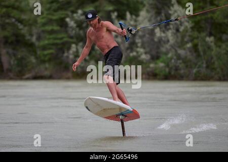 Todd Ril-Surfen (Foil Boarding) während des Flußes im Frühling im Bow River, Canmore, Alberta, Kanada. Stockfoto