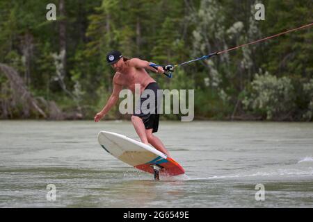 Todd Ril-Surfen (Foil Boarding) während des Flußes im Frühling im Bow River, Canmore, Alberta, Kanada. Stockfoto