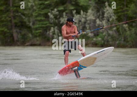 Todd Ril-Surfen (Foil Boarding) während des Flußes im Frühling im Bow River, Canmore, Alberta, Kanada. Stockfoto