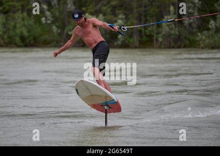 Todd Ril-Surfen (Foil Boarding) während des Flußes im Frühling im Bow River, Canmore, Alberta, Kanada. Stockfoto