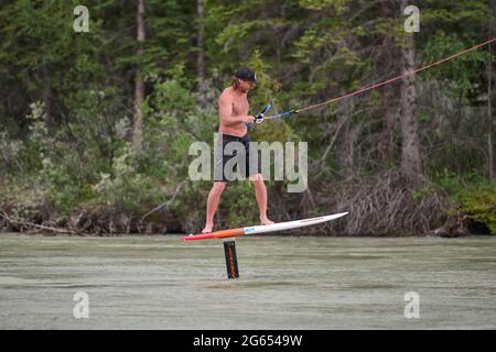 Todd Ril-Surfen (Foil Boarding) während des Flußes im Frühling im Bow River, Canmore, Alberta, Kanada. Stockfoto