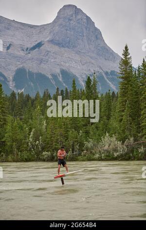 Todd Ril-Surfen (Foil Boarding) während des Flußes im Frühling im Bow River, Canmore, Alberta, Kanada. Stockfoto