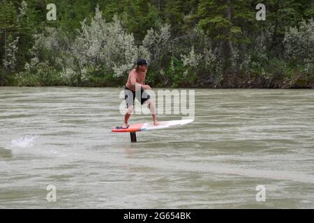 Todd Ril-Surfen (Foil Boarding) während des Flußes im Frühling im Bow River, Canmore, Alberta, Kanada. Stockfoto