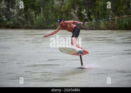 Todd Ril-Surfen (Foil Boarding) während des Flußes im Frühling im Bow River, Canmore, Alberta, Kanada. Stockfoto