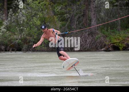 Todd Ril-Surfen (Foil Boarding) während des Flußes im Frühling im Bow River, Canmore, Alberta, Kanada. Stockfoto