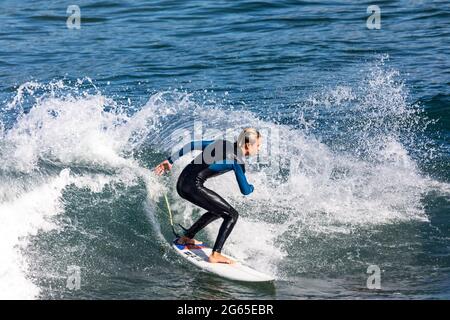 Junger australischer Teenager-Junge im Neoprenanzug, surft und dreht sich auf einer Welle am Avalon Beach in Sydney, NSW, Australien Stockfoto