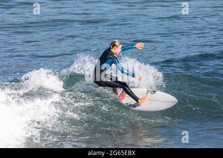 Junger australischer Junge im Teenageralter im Neoprenanzug beim Wellenreiten am Avalon Beach in Sydney, Australien Stockfoto