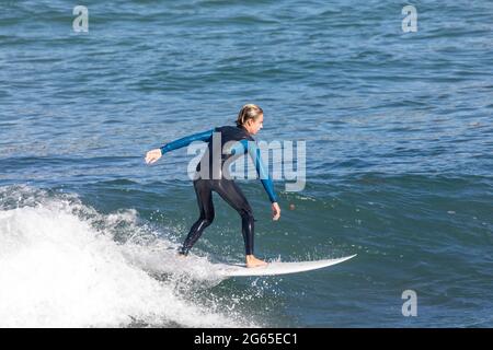 Junger australischer Junge im Teenageralter im Neoprenanzug beim Wellenreiten am Avalon Beach in Sydney, NSW, Australien Stockfoto