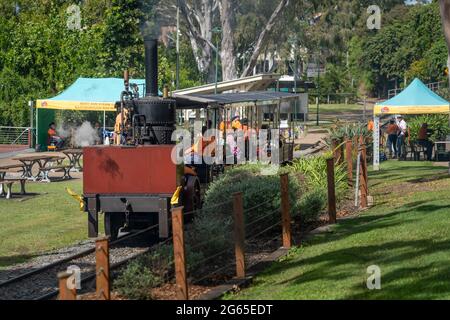 Touristen fahren auf der Mary Ann Replik Dampflokomotive in Maryborough Qld. Australien Stockfoto