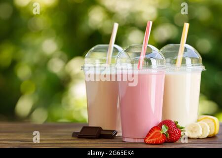 Set aus verschiedenen Milchshakes in Einweg-Plastikgläsern Stockfoto