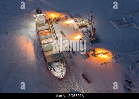 Sabetta, Region Tjumen, Russland - 07. Dezember 2020:das Schiff ist im Frachtbetrieb am Liegeplatz tätig. Das Schiff ist im Eis eingefroren. Stockfoto