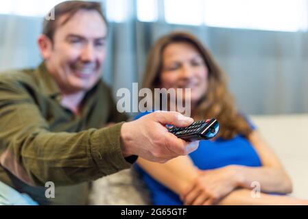 Reifer Mann und Frau auf der Couch und schauen sich einen Film an. Stockfoto