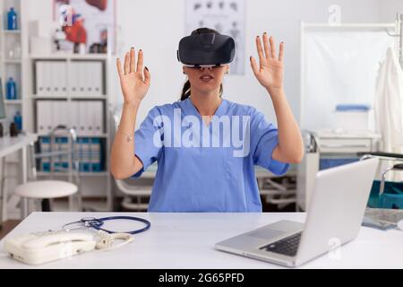 Gesundheitsarzt mit medizinischen inovation tragen Virtual-Reality-Brille im Krankenhaus Büro. Therapeut mit medizinischen Innovation Geräte Geräte Brille, Zukunft, Medizin, Arzt, Gesundheitswesen, professionoanl, Vision, Simulator. Stockfoto