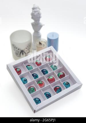 Gehärtete Schokolade Bonbons mit glänzend lackiertem Körper in einer Box mit verschwommenem Hintergrund und Bokeh-Elemente. Stock-Fotografie. Stockfoto