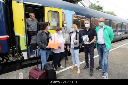 03. Juli 2021, Mecklenburg-Vorpommern, Rostock: Der erste Urlaubsexpress aus Basel ist am Bahnhof Rostock-Kassebohm angekommen, wo sich die beiden vor der Tür von der Tourismusvereinigung Mecklenburg-Vorpommern, Katrin Hackbarth, Holger Matthäus (Bündnis 90/die Grünen), Senator für Verkehr in Rostock, und Matthias Fromm, Tourismusdirektor in Rostock, begrüssen. Der Nachtzug fährt von der Schweiz über Hamburg nach Binz auf der Ostseeinsel Rügen. Nach den Plänen des privaten Kölner Bahnanbieters Train4You pendelt der Zug Stockfoto