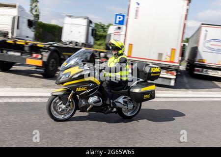 02. Juli 2021, Nordrhein-Westfalen, Königsforst: Staubberater Herbert Kleefuß vom ADAC fährt auf dem Rastplatz Königsforst West mit seinem Motorrad an Lastwagen vorbei. Foto: Marcel Kusch/dpa Stockfoto