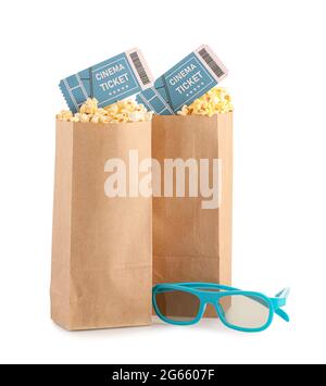 Papiertüten mit leckerem Popcorn, Kinokarten und 3D-Brillen auf weißem Hintergrund Stockfoto