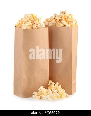 Papiertüten mit leckerem Popcorn auf weißem Hintergrund Stockfoto