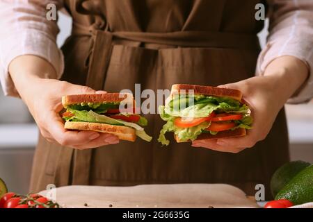 Frau hält leckere Sandwiches in der Küche, Nahaufnahme Stockfoto