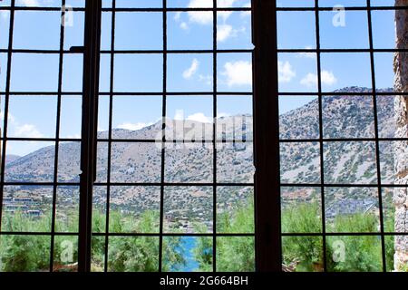 Insel Spinalonga, EIN Blick auf die schöne Welt aus dem Fenster der Gefängniszelle, Krete, Griechenland Stockfoto